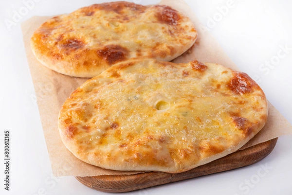 Obraz Homemade Ossetian pies on a wooden board on a white background. Homemade food concept.