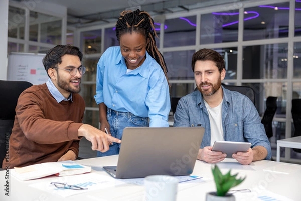 Fototapeta Group of diverse businesspeople using laptop while working together