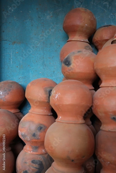 Fototapeta pots are gathered and arranged in a pattern in the empty space. The potter works on a pottery wheel to made of soft colored clay, retro style toned Clay pots with hand and equipment