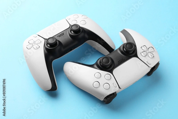 Fototapeta Wireless game controllers on light blue background