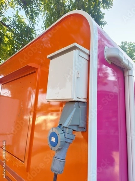 Obraz Industrial electric cable sockets are mounted on orange concrete poles.
