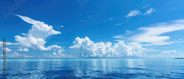 Fototapeta A beautiful blue sky with clouds and a calm ocean
