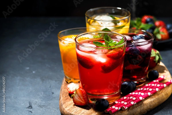 Obraz cold fruit and berry beverages in assortment on dark table