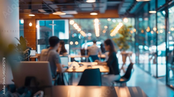 Obraz Blurred office interior with business people working in a team, sitting at desks and using computers. Concept of corporate life or work culture.