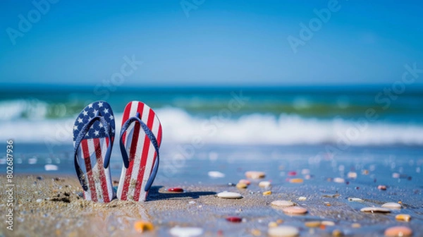 Obraz American flag flip flops on sandy beach with seashells