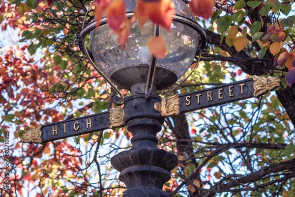 Fototapeta A lamp post in Northcote, Victoria, Australia featuring a glass dome light, and the High Street name in gold lettering.