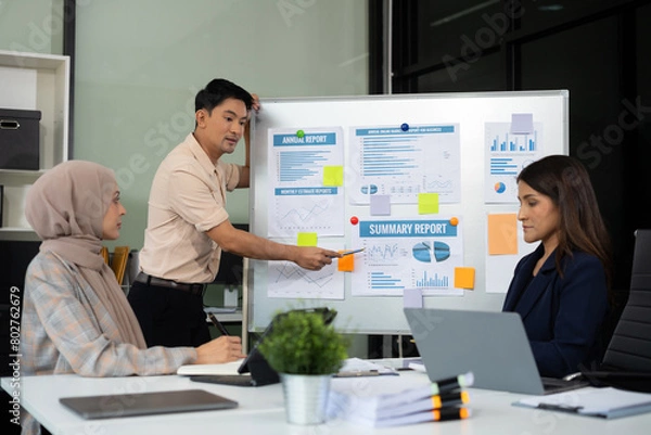 Obraz businessman showing hand and smiling young team of colleagues making good business discussion in modern coworking office concept teamwork people.