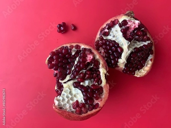 Obraz pomegranate fruit in section isolated on red background 