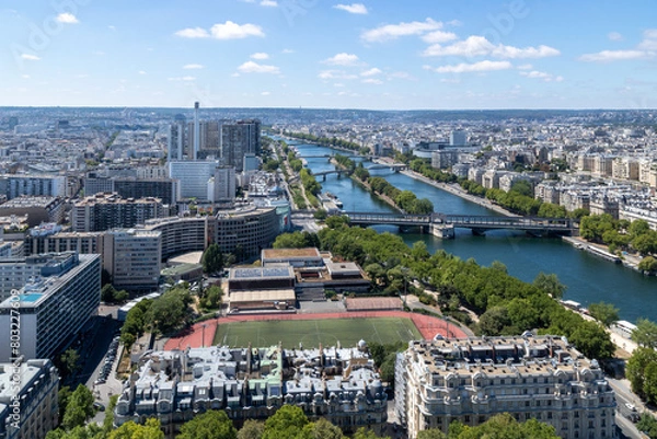 Fototapeta Panoramic view of Émile Anthoine Stadium, the roofs of the buildings around the Tour Eiffel and Seine river, Paris, France.