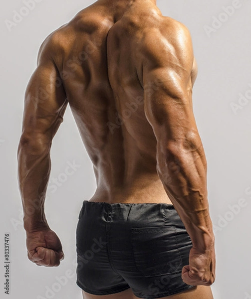 Fototapeta Bodybuilder showing his back and biceps, triceps muscles
