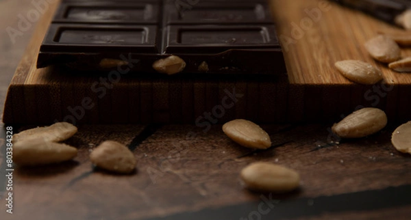 Obraz Tableta de chocolate negro con almendras sobre madera