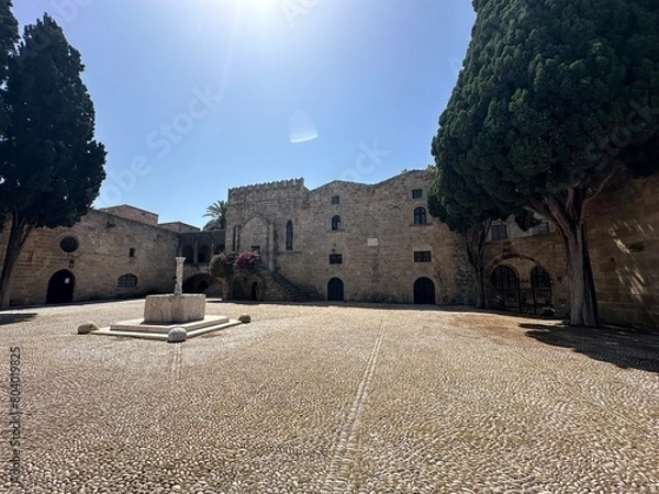 Obraz Old town square with fountain and ancient stone buildings at medieval city of Rhodes, Greece
