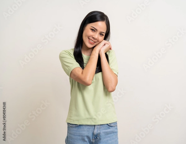 Fototapeta Beautiful smiling happy young asian woman age around 25 in green shirt. Charming female lady standing pose on isolated white background. Asian woman people looking camera confident with backdrop.