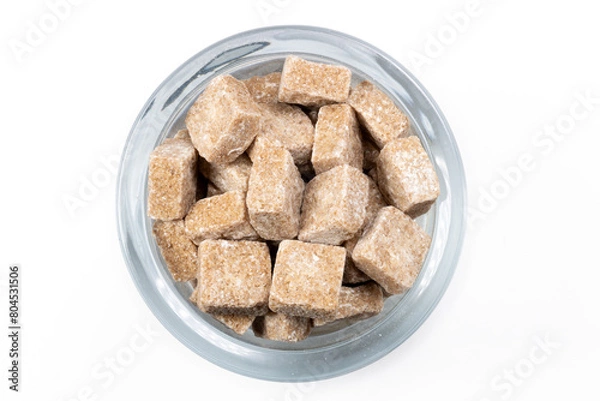 Fototapeta A glass full of brown cane sugar cubes
