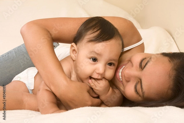 Obraz Mother playing with her baby boy son on bed