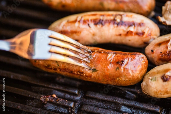 Fototapeta Barbecued beef and pork sausage on fork