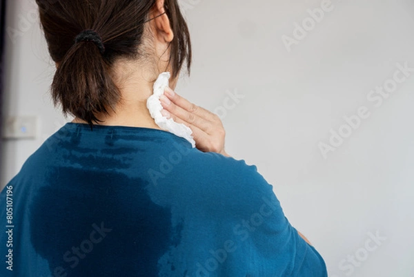 Obraz back view of sweating woman with wet cloth because of hot weather in summer time, menopause symptom concept