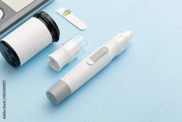 Fototapeta Glucometer on a blue background. Device for measuring blood sugar levels. Top view. Space for text.