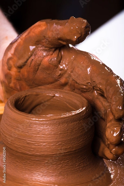 Obraz hand of potter working on pottery wheel, closeup