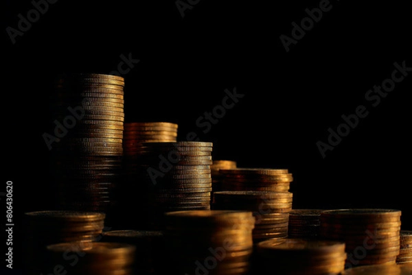 Fototapeta A large variety of coins on a black background. Stack of coins