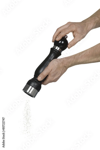 Obraz Two caucasian male hands using a pepper grinder