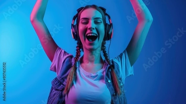 Fototapeta Discover the Secrets of the Universe While Dancing with Headphones On Blue Background.