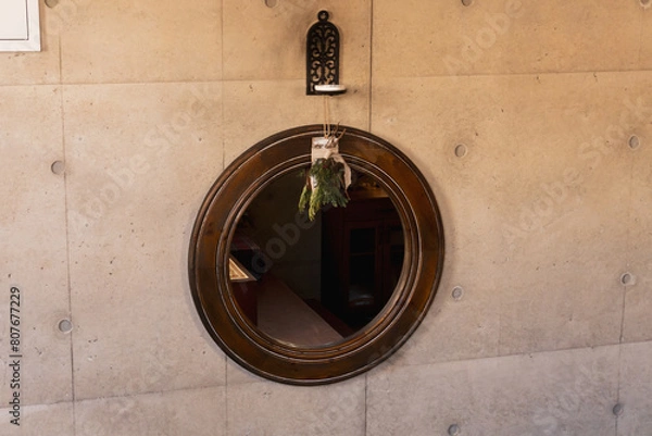 Obraz Vintage room with wooden round mirror hanging on the wall with ornamental plant hanging