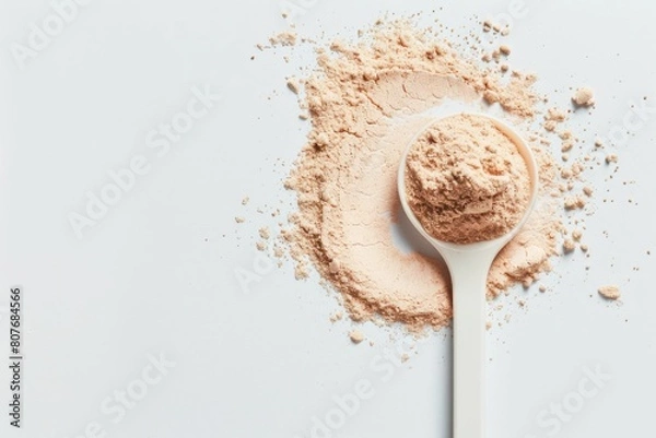 Fototapeta Plastic spoon filled with plant-derived keto protein powder on an isolated background. Space to copy additional text or design elements