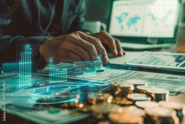 Obraz Digital hologram showing financial growth graph  coins and document on table. Businessman working on a computer, screen showing the world map