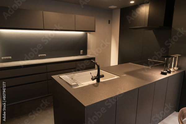 Fototapeta スタイリッシュでシックなシステムキッチンとウォールナットの一枚板ダイニングテーブル