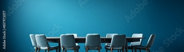 Fototapeta A large round table with multiple chairs around it, symbolizing inclusivity and discussion, set against a conference room blue background.