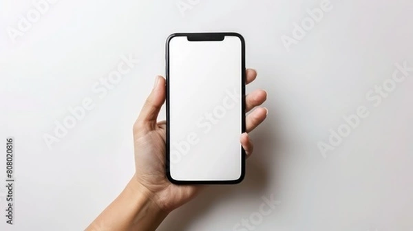 Fototapeta a hand holding a smartphone mockup with a blank white screen, isolated on a white background. This versatile image is perfect for website design, mobile app promotion, and advertisements