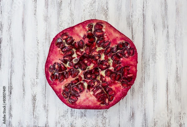 Fototapeta Pomegranate section overhead view on a white wooden kitchen table