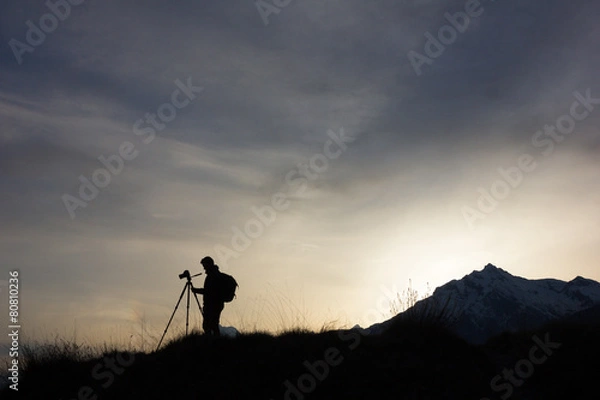 Obraz Sylwetka profesjonalnego fotografa używającego statywu