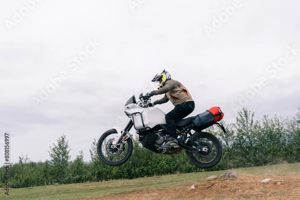 Fototapeta Motorcyclist jumping on adventure tourist enduro motorcycle outdoor on training area