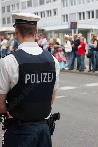 Obraz Polizist vor einer Menschenmenge