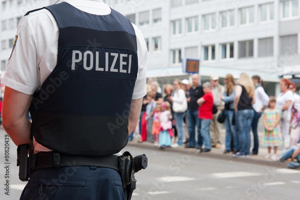Obraz Polizist vor einer Menschenmenge