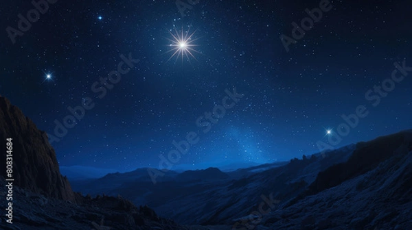 Obraz Brightest Sirius star shines in the night sky over an ancient mountain landscape, symbolizing Jesus' birth and Christmas, with other stars visible in the background