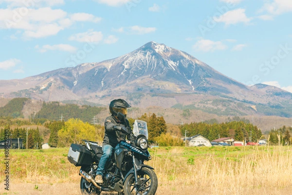Fototapeta 雪が残る春の磐梯山をバックにバイクとライダー