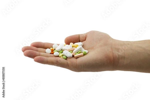 Fototapeta Heap of different pills, tablets and capsules in the man hand 
