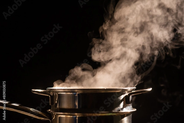 Fototapeta A boiling pot steams up as a chef cooking steam food in steam pot in a restaurant.	