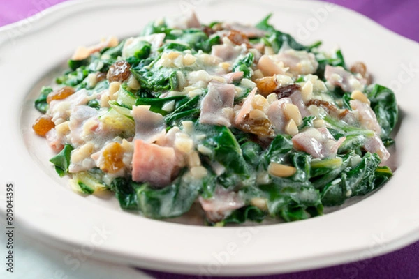 Fototapeta Plate of boiled acellgas with ham, raisins and pine nuts in skim milk sauce