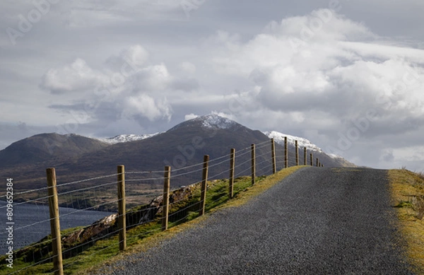 Obraz Country Road in Connemara, West of Ireland with snow capped mountains in the background