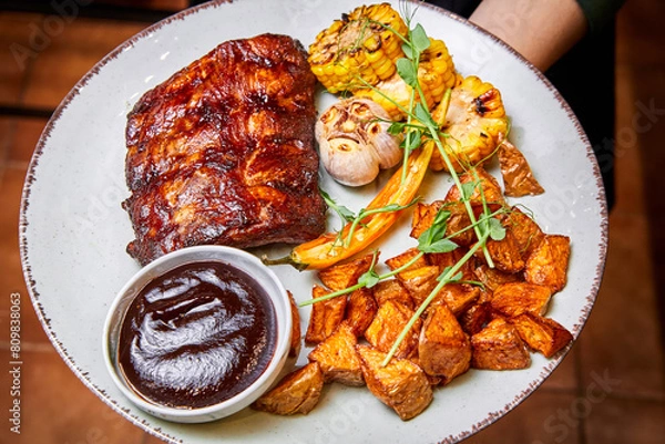 Obraz Grilled pork ribs with corn on the cob and baked potatoes