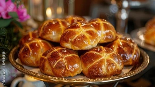 Fototapeta A platter of freshly baked hot cross buns, their glossy crusts adorned with the traditional cross symbol