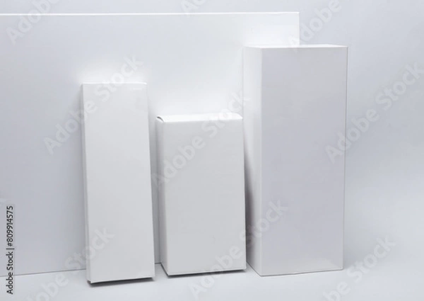Fototapeta Different shapes of white cardboard boxes for presentation products on white background. Mockup for design.