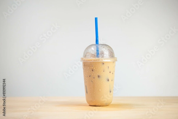 Fototapeta Iced coffee mocha or coffee latte in takeaway cup on wooden table. coffee package for takeaway, Cold beverage product.