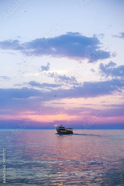 Fototapeta Beautiful sunset over calm sea, with vivid colors and clouds in the sky. Serenity and nature concept