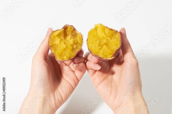 Obraz 삶은 고구마를 양손으로 쪼개어 보인다