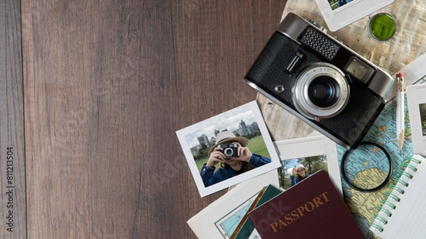 Obraz Photographs of woman taking photos, passports, old photo camera, map and notebook on a dark wooden table